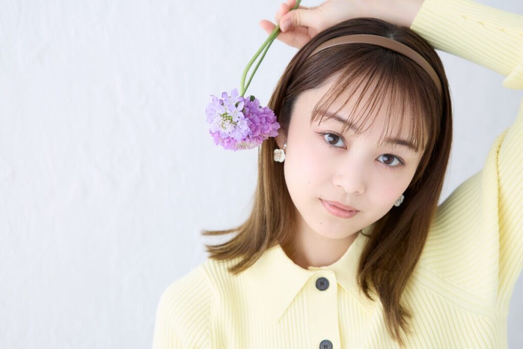片手に紫色の花を持った元タカラジェンヌ舞空瞳さん
