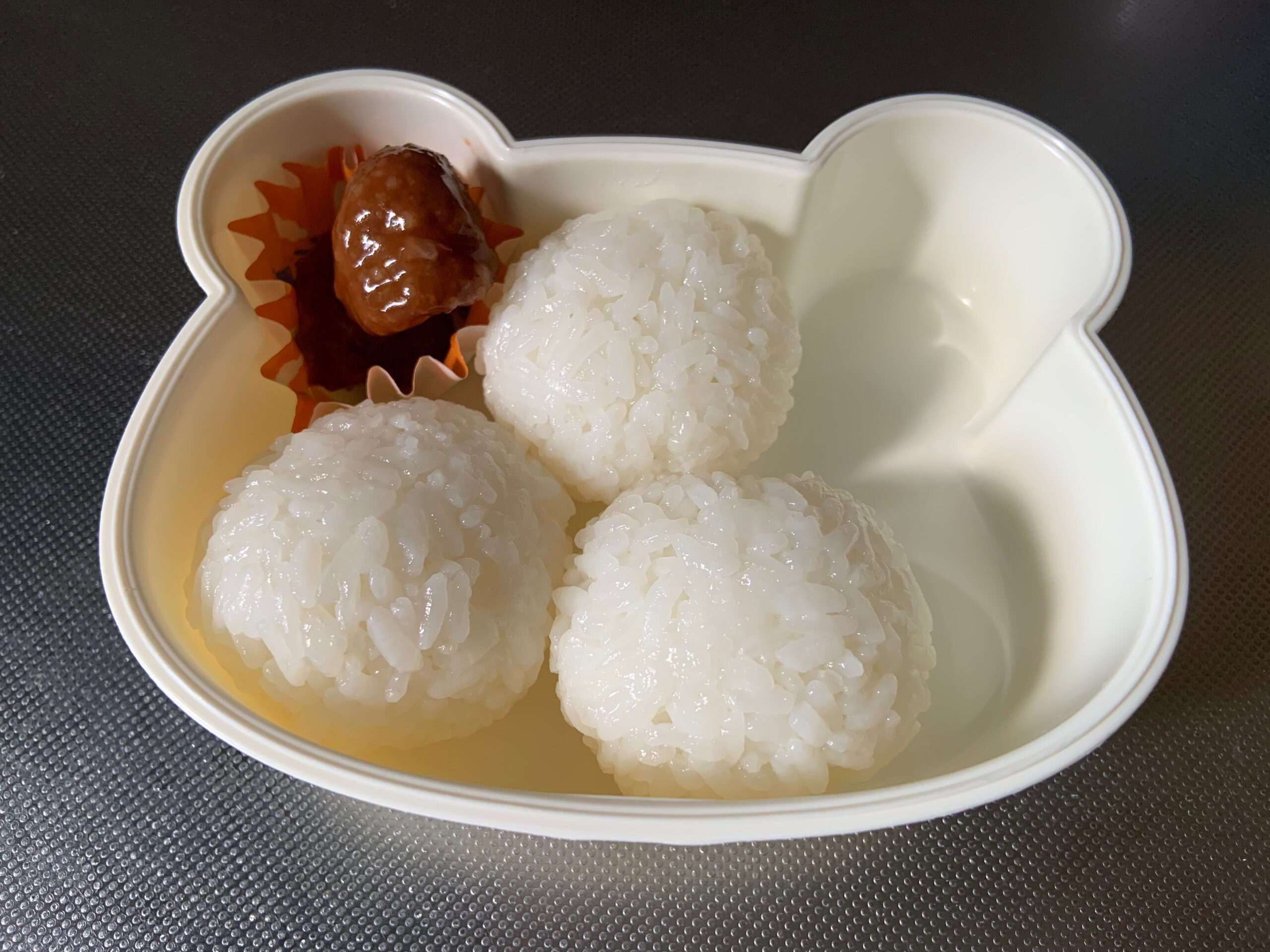 子供のお弁当を作る様子。おにぎりとミートボール。
