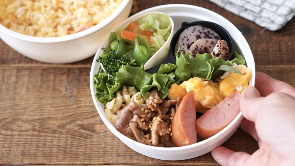 セリアの白い2段弁当に、ソーセージと卵、豚焼肉、キャベツ、にんじん、スナップエンドウ、ブロッコリーを詰めたお弁当。中学生弁当。朝ごはん詰めるだけ。100円のかわいいお弁当箱。中学生が喜ぶ弁当。