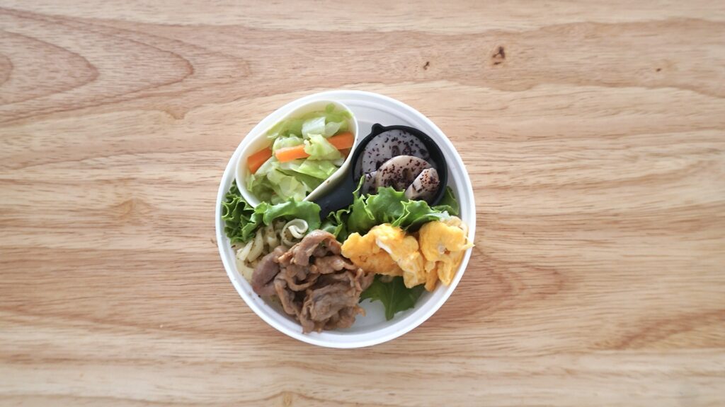 セリアの白い2段弁当に、ソーセージと卵、豚焼肉、キャベツ、にんじん、スナップエンドウ、ブロッコリーを詰めたお弁当。中学生弁当。朝ごはん詰めるだけ。100円のかわいいお弁当箱。中学生が喜ぶ弁当。