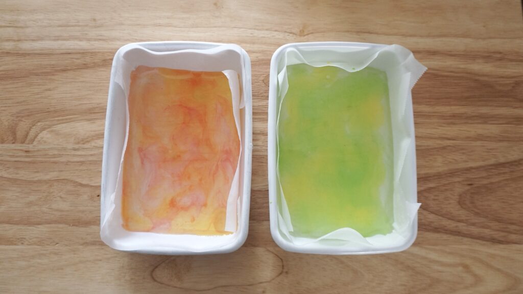 かき氷シロップで作れる簡単な琥珀糖。ダイソーでも買えるシロップ、メロン、いちご、レモンを使っています。とても簡単に寒天と砂糖と水で作ることができます。野田琺瑯のバットに流し入れ、固めています。