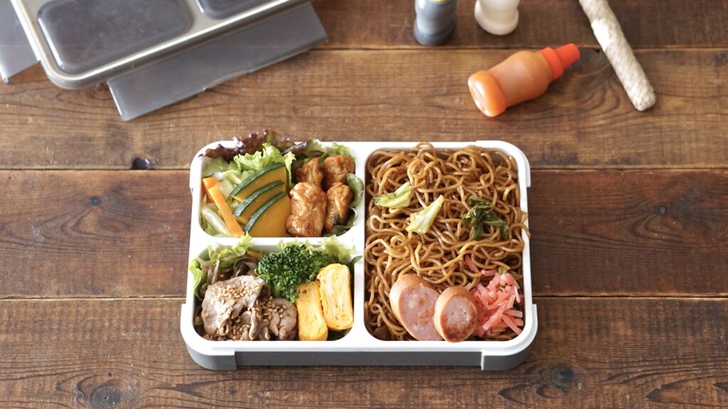 フードマンを使った夫のお弁当。夜におかずを詰めておき、朝に焼きそばを詰めるだけのお弁当。おかずのストックを味付けしなおして詰めるだけなので、とても簡単です。卵焼き、焼き肉、かぼちゃ、キャベツ。別添えにソースとワカメスープを一緒に入れておきます。