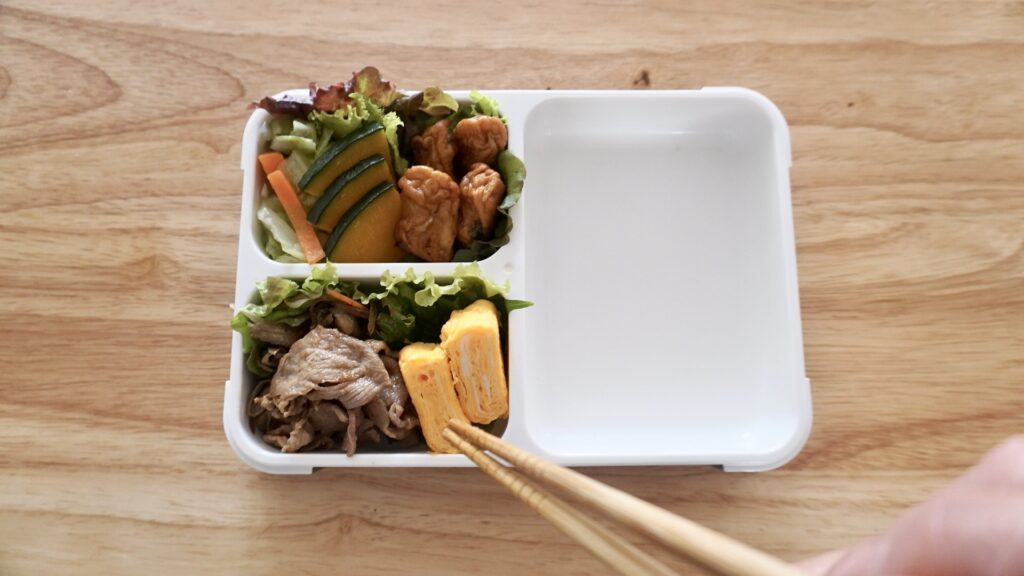 フードマンを使った夫のお弁当。夜におかずを詰めておき、朝に焼きそばを詰めるだけのお弁当。おかずのストックを味付けしなおして詰めるだけなので、とても簡単です。卵焼き、焼き肉、かぼちゃ、キャベツ。別添えにソースとワカメスープを一緒に入れておきます。