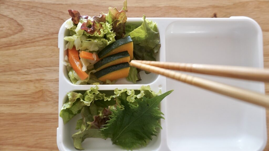 フードマンを使った夫のお弁当。夜におかずを詰めておき、朝に焼きそばを詰めるだけのお弁当。おかずのストックを味付けしなおして詰めるだけなので、とても簡単です。卵焼き、焼き肉、かぼちゃ、キャベツ。別添えにソースとワカメスープを一緒に入れておきます。