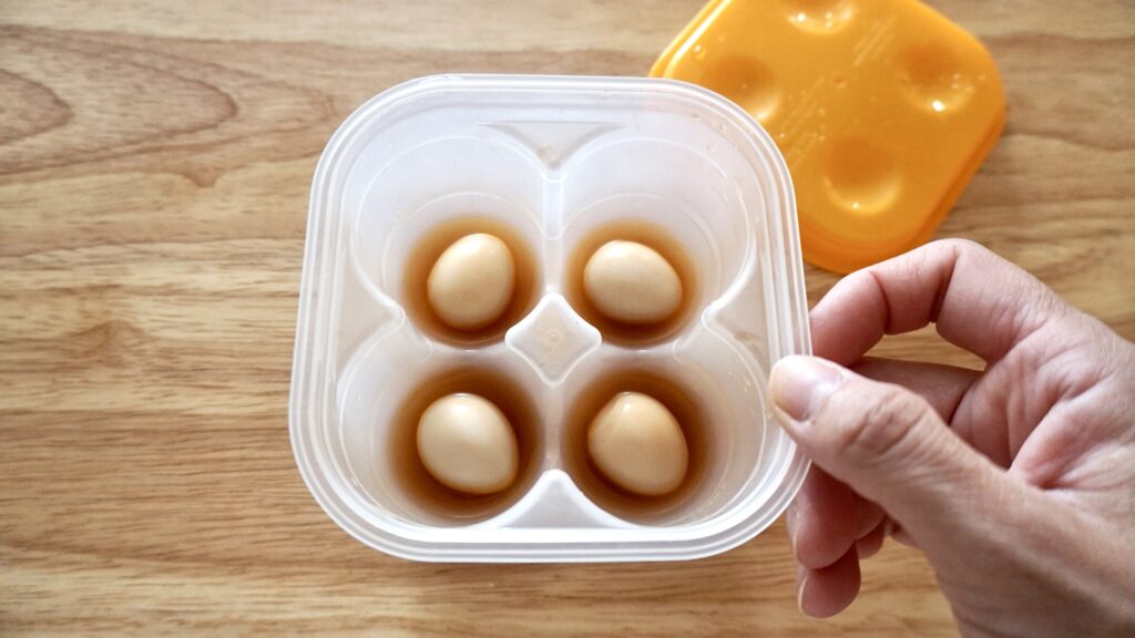 うずらの卵をダイソーの味玉用容器に入れて、出汁醤油に漬ける。