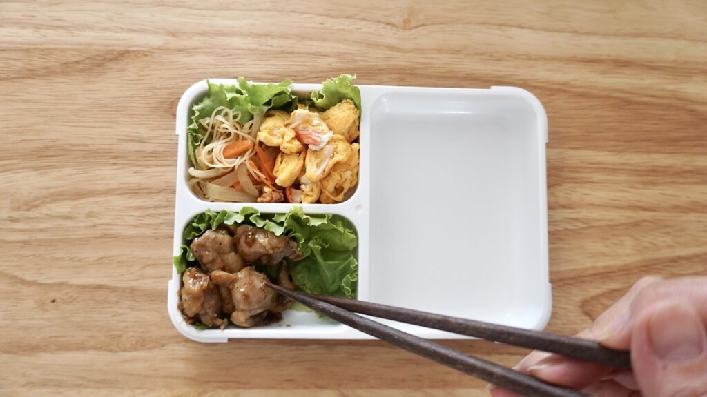 フードマンで作る夫弁当。前日の夜ご飯から、ビーフンを少し残して詰めています。カニカマと卵炒め、鶏の照り焼き、酢蓮根、ソーセージ、筑前煮。