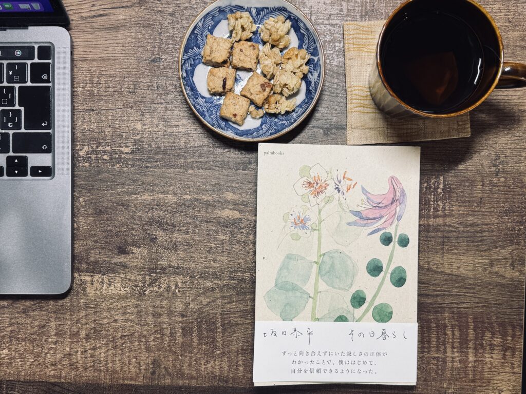 坂口恭平著「その日暮らし」をおやつ片手に読書する様子